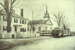 Starting in 1898, the main roads in Norton heading to Mansfield, Easton, Taunton and Attleboro were shared with Trolley cars. Powered by electric lines, the trolleys were a main source of transportation to not only get around town, but to take individuals into the neighboring towns, as very few people owned automobiles until the 1920s. The trolleys would go as far as the next town, and passengers would have to disembark and take another trolley to go to the next town. Norton had its own power station, a building that was on Powers St. (Can you guess how they came up with that name?) The Norton Historical Society has a number of pictures of trolleys traveling through the center of town, down Mansfield Ave, North Worcester St, or down on Taunton Ave. The trolley cars were housed in the Car Barn, which later became the Norton Center Garage where Walgreens now stands. The Trolleys were originally owned by private businesses, but when they went bankrupt, the towns of Attleboro, Mansfield, Taunton and Norton took them over becoming the N.T. & A. ST. R. R. Finally in 1928, rider-ship was way down, and the company finally folded. The last trolley ride to leave Norton was on July 22, 1928. The cars and equipment were sold off to try to recoup some of the money that the towns put into the business. Two of the trolley cars were sold to Bill Jette which he used for a restaurant called the Polo Diner on Taunton Ave. This picture shows a trolley car coming out of Taunton Avenue with the Wheaton Inn on the left and the Unitarian Church on the right.