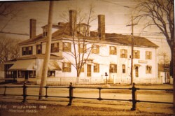In 1819, Judge Wheaton, the founder of Wheaton College, purchased a beautiful mansion on the corner of what is now known as East Main Street and Taunton Avenue where he and his family lived. After Judge Wheaton established the Wheaton Seminary in memory of his daughter Eliza Wheaton Strong in 1834, the mansion was used as a dormitory to house students before a permanent boarding house was built for the girls at the seminary. After the Wheatons left this home, the mansion was used as a hotel that was aptly named "The Mansion House", and then later became the Wheaton Inn in 1928. This building had four chimneys, with eight fireplaces, 4 downstairs and 4 upstairs, two dining rooms and a very large kitchen area. It was a wonderful place for families who came to town to visit their daughters at the Wheaton Seminary (which became Wheaton College in 1912), as well as The House in the Pines. A 1930 receipt showed a $5 charge for a night at the inn. The inn was also used by young boys who would come to Norton to court their Wheaton girlfriends, under the supervision, of course, of those running the inn. At one time, the Wheaton Inn also housed the Post Office and the Telephone Exchange.
In the early 1960s, Wheaton College closed the inn down as an eating and lodging establishment, as they wanted to use it once again as a dormitory. In an undated newspaper article regarding the closing, it was stated that the college was going to use the building "one way or another" because of its handsome architectural qualities and "not one of those alternatives includes tearing the building down". After one year of using it as a dormitory, they left it vacant until the trustees of Wheaton College agreed unanimously to do what they said they wouldn't do; tear it down. The Norton Historical Society, as well as alumni, experts on colonial architecture, and others disagreed with their decision. There were several offers of financial assistance to help preserve the building, but, nonetheless, the building was torn down in 1965 due to the "prohibitive" restoration costs of $100,000, to make way for landscaping. Today, while sitting at the center traffic light on Taunton Ave, you can see a stone base with the "Wheaton College" sign on top at the corner near the Post Office that marks the spot where that beautiful mansion, the home of Judge Laban Wheaton, businessman, congressman, and founder of the Wheaton Seminary, once stood.